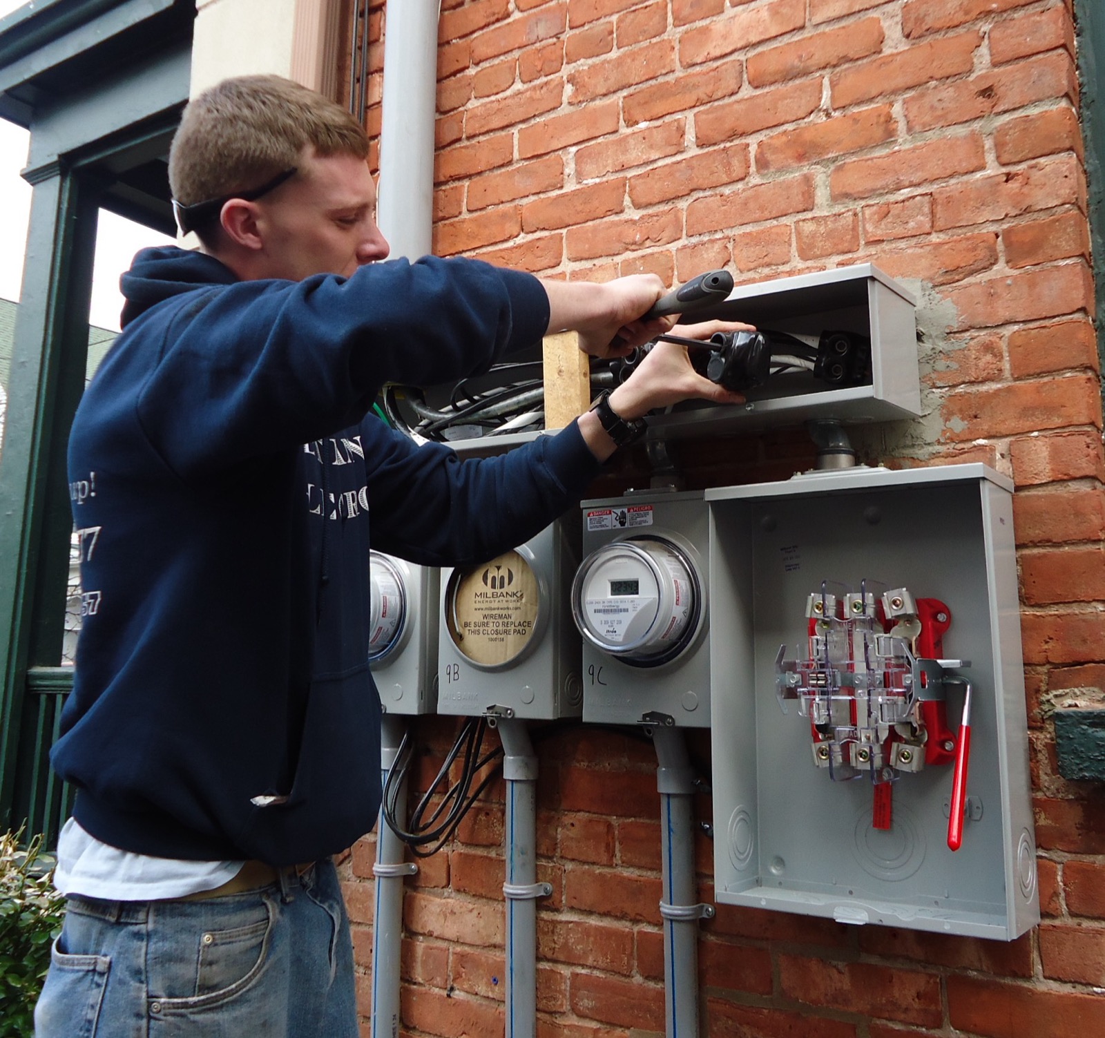 Licensed electrician working on an electrical panel on the exterior of a Port St. Lucie home